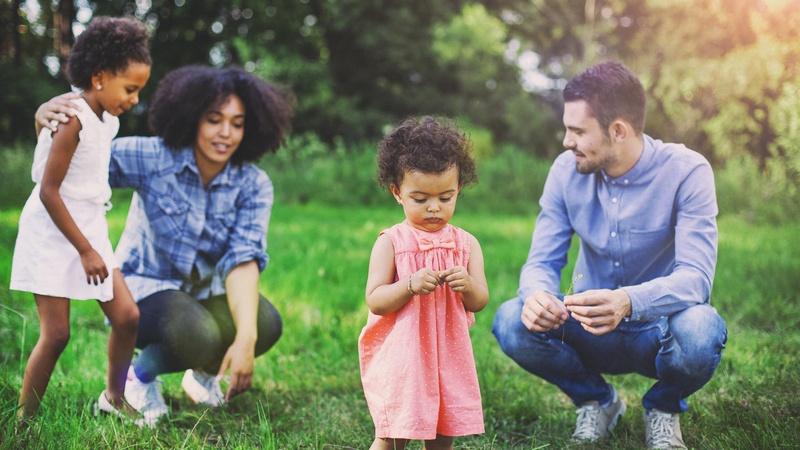 Parents and two children exploring nature on a walk.