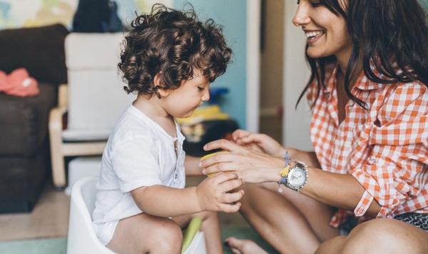 Image of mother teaching her son to use the potty.