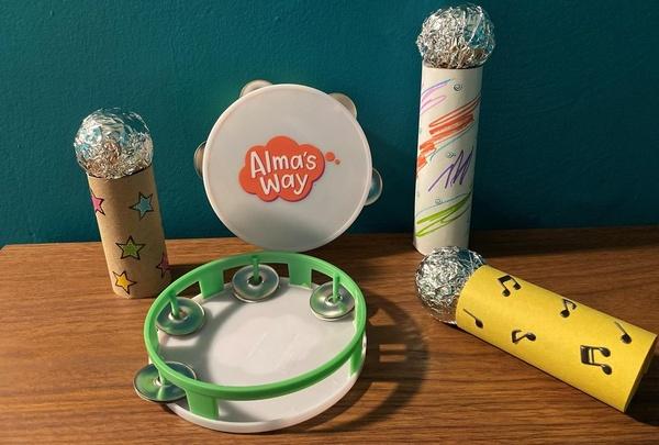 Several microphone crafts and some tambourines sitting on a table.