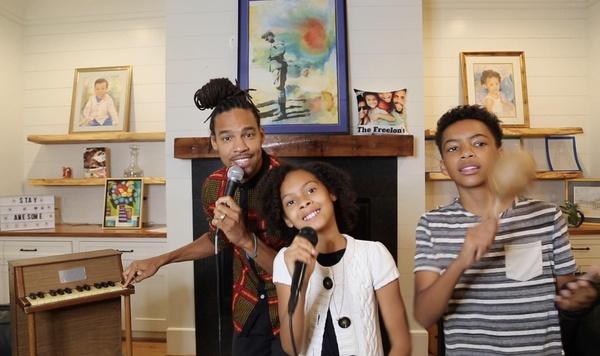 Pierce Freelon and his children singing and playing musical instruments.