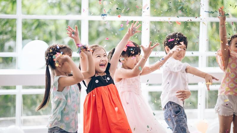 Group of children throwing confetti in the air.