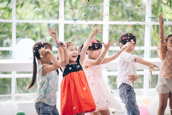 Group of children throwing confetti in the air.