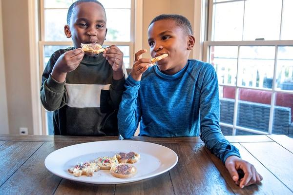 Dos niños saborean galletas maravillosas para el invierno.