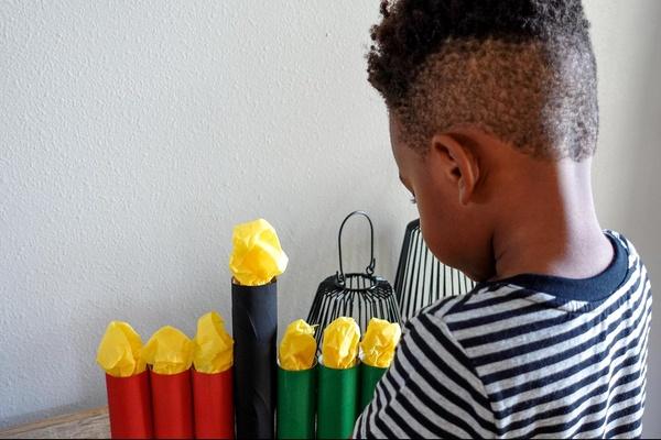 A child admires his finished DIY Kwanzaa Kinara.