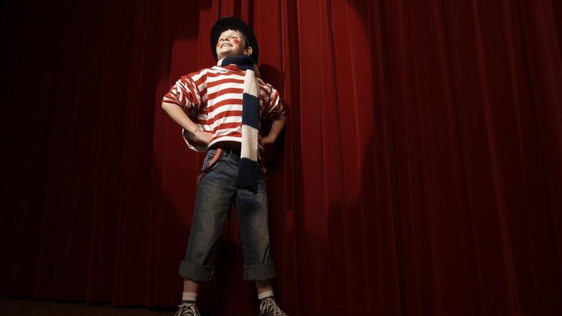 Un niño demuestra confianza mientras actúa en el escenario.