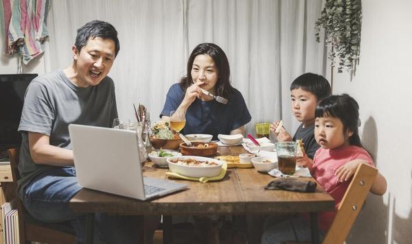 Family eating dinner and enjoying a video call.