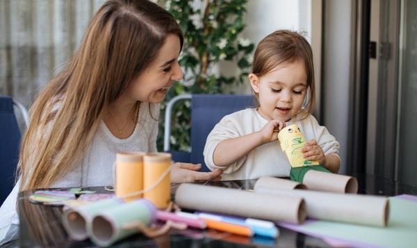 Image of mother and preschool daughter making crafts from paper towel rolls.
