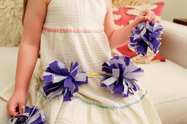 Child holding pom pom garland.