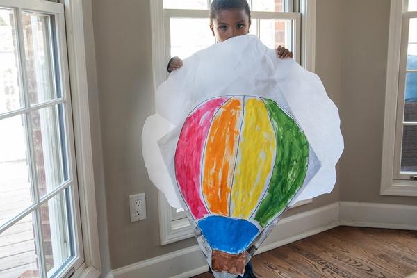 Boy holds the colorful paper kite he made.