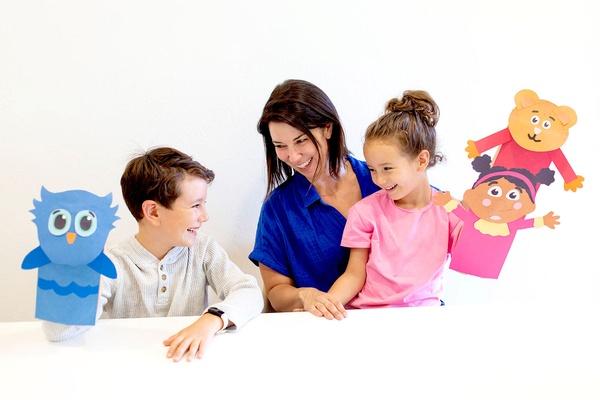 A family plays with their paper bag puppets.