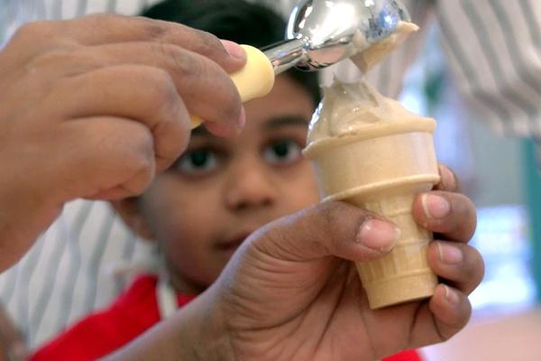 A mother serves her son a banana swirl treat.
