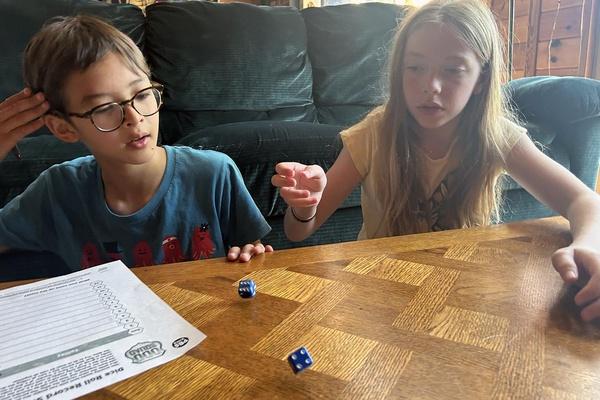 A boy and girl roll two dice.