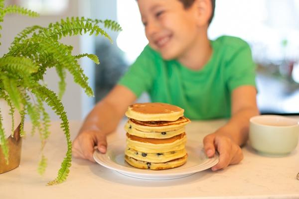 A boy shows off a plateful of flying flapjacks that he made for breakfast.