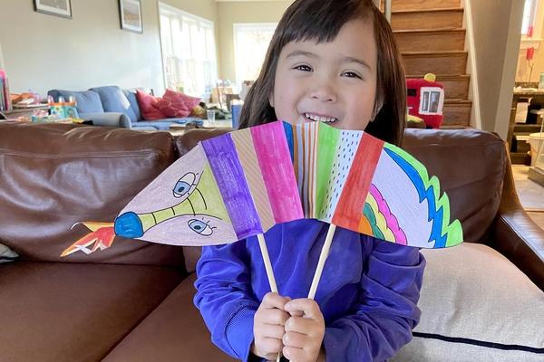 A child holds their dragon puppet craft for the lunar new year.