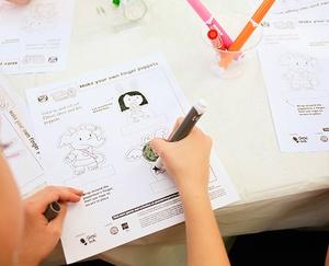 Child coloring in puppets.