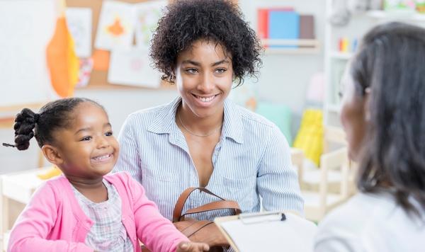 Mother and daughter meeting with the teacher at school.