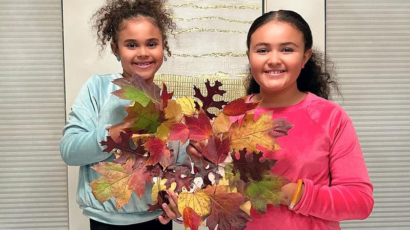 Children show off their fall leaf color wheel wreath.