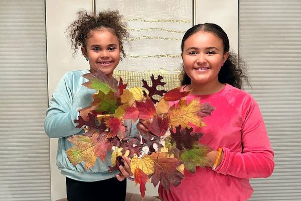 Children show off their fall leaf color wheel wreath.