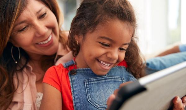 Grandmother and granddaughter playing on a tablet.