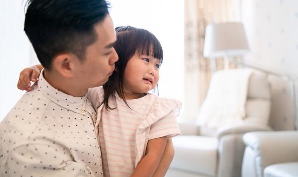 Father consoling his sad young daughter.