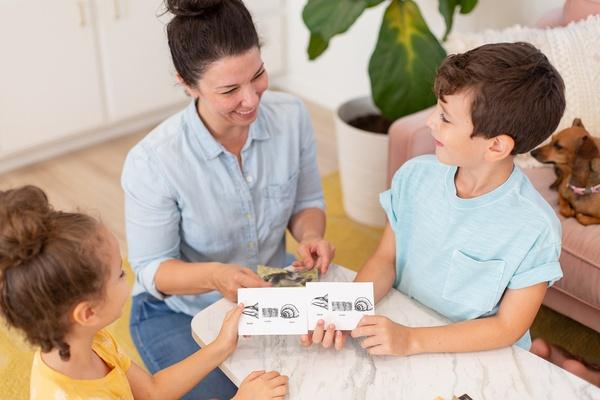 A parent and two children play the animal match-up game.