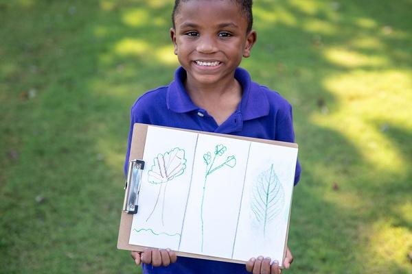 A child holds a picture that displays plant patters