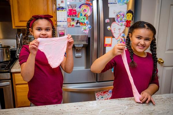 Two sisters make slime together.