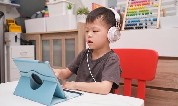 Young boy engaging with a tablet.