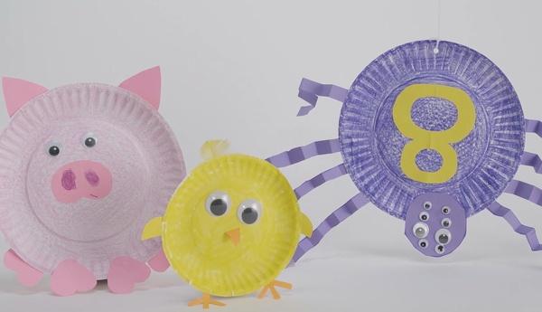 An image showing a pig, chick, and spider made from paper plates. A question asks how many legs each animal has.