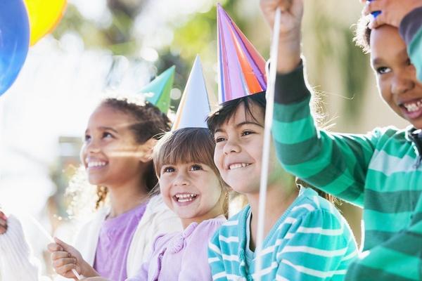 Group of children wearing birthday hats.
