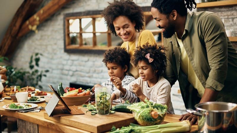 Una familia prepara una comida saludable juntos.