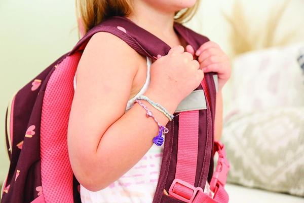 A child wears thinking of you bracelets.