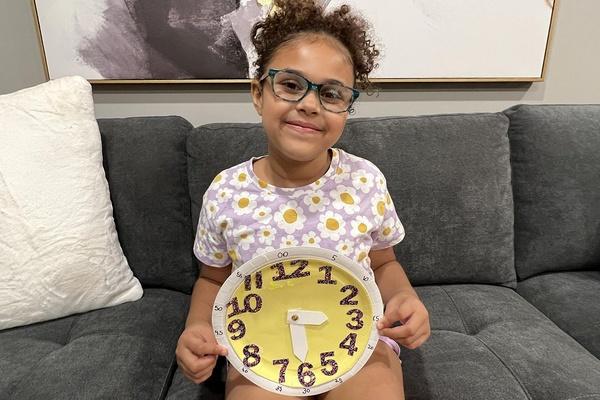 Child holding a completed clock.
