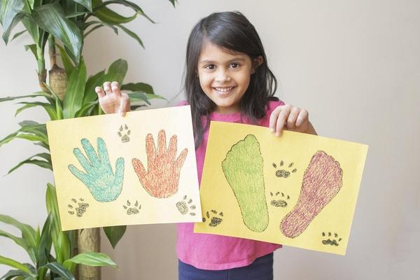 Girl holds tracks she made with sister.