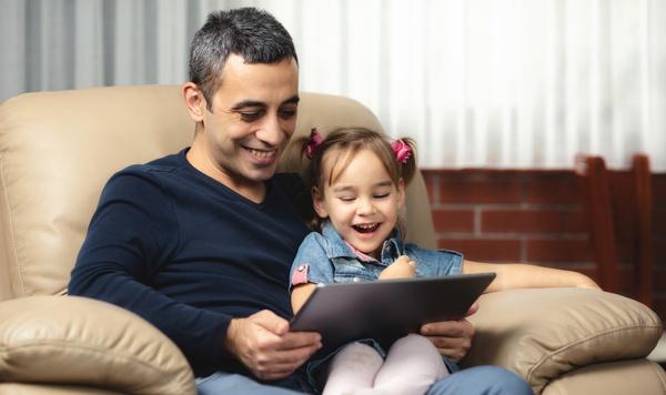Father and daughter playing with a tablet.