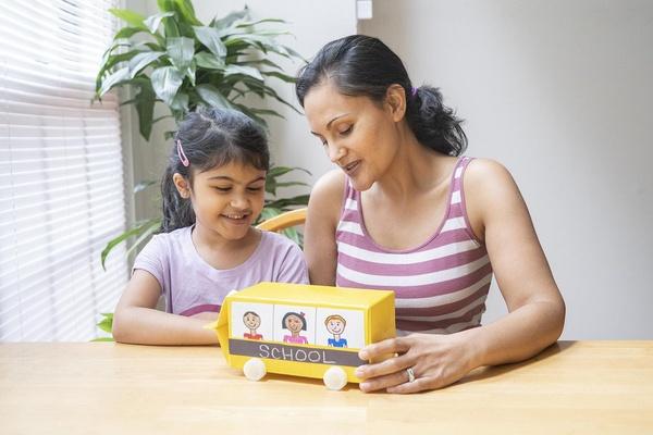 A mother and daughter make a school bus together.