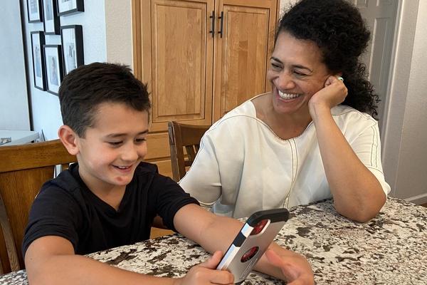 A mother and son create an audio message together.