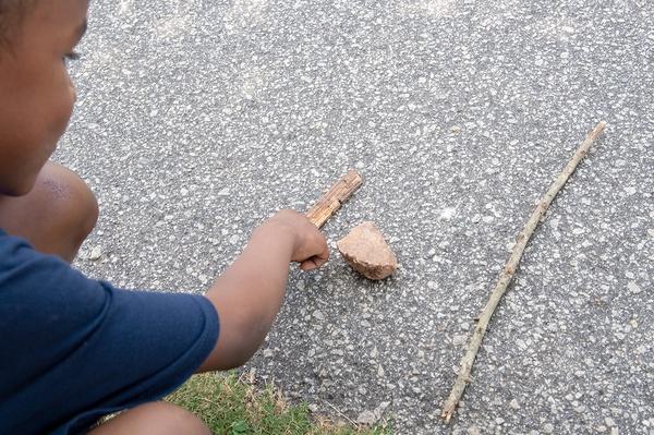 A boy admires his natural tools.