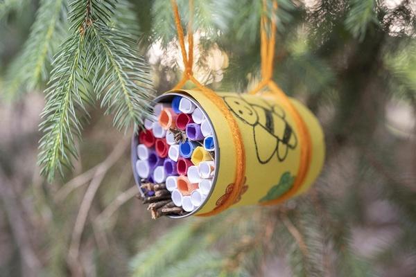 A wild bee hotel hangs in a tree.