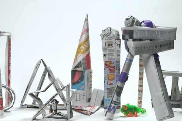 Pieces of newspaper rolled, folded, and taped together to make different structures.
