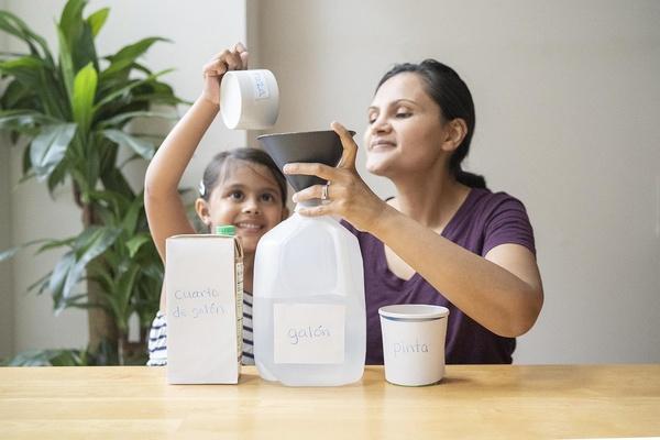 Una madre y su hija aprenden sobre las mediciones con juegos de agua.