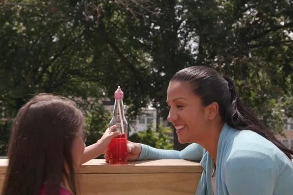 Una madre y su niña examinan su termómetro de botella.