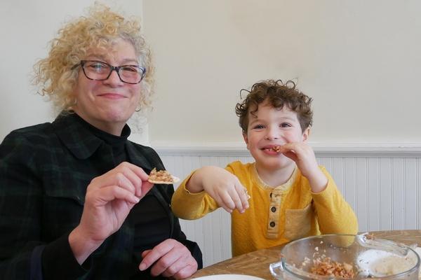 A child enjoys eating charoset with his grandmother.