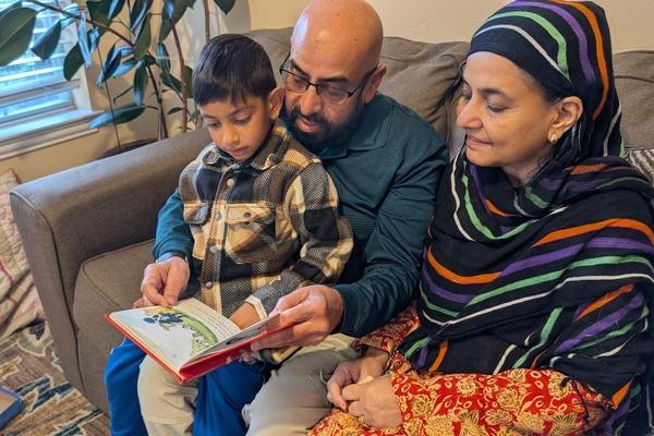 Family reading a book together.