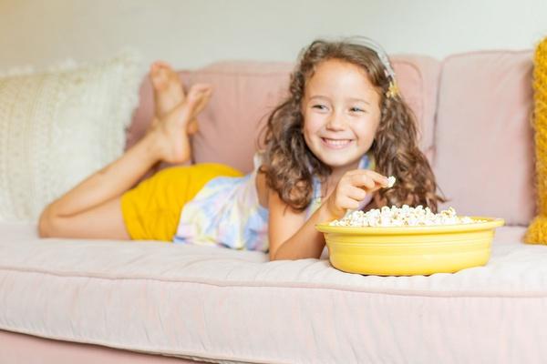 Child enjoying cheesy popcorn.