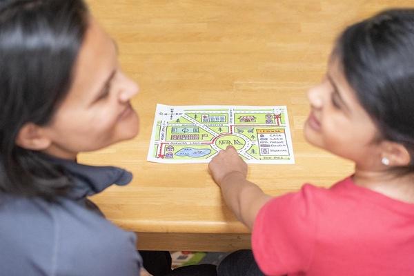 Viendo el mapa, una mamá y su hija conversan sobre un viaje que hicieron juntas.