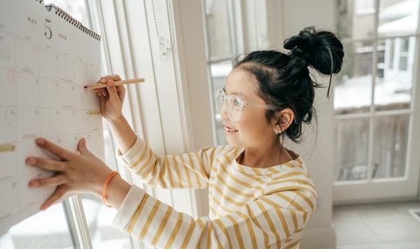 Image of girl writing on a calendar.