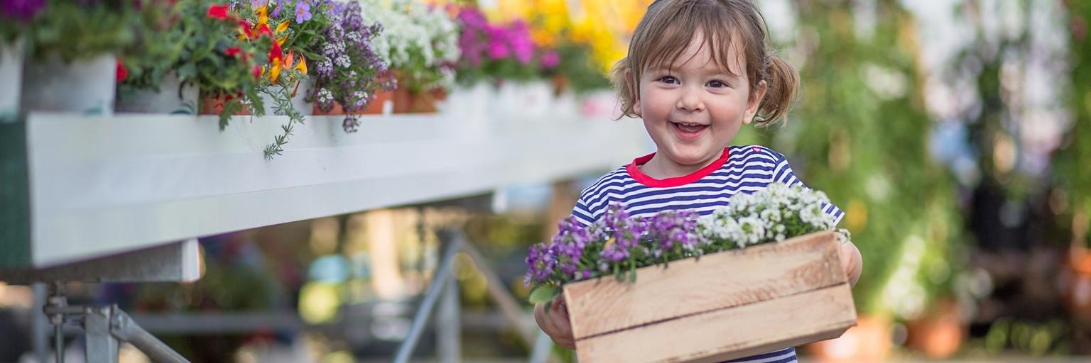 Niña llevando flores.
