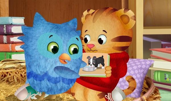 O looks a book that Daniel Tiger is holding.
