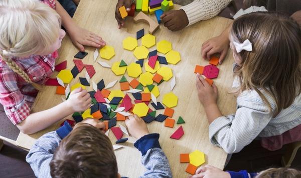 A group of children playing with shape toys.
